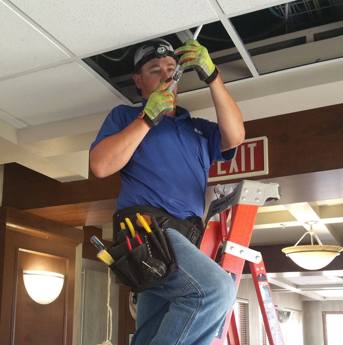 Jordan Brown working in the ceiling, preparing to install equipment to feed the Green wing